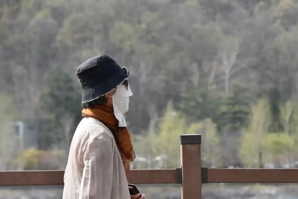 FLANERANDE KVINNA MED MASK FÖR ANSIKTET. FÖR ATT INTE BLI SOLBRÄND, SA NÅGON.