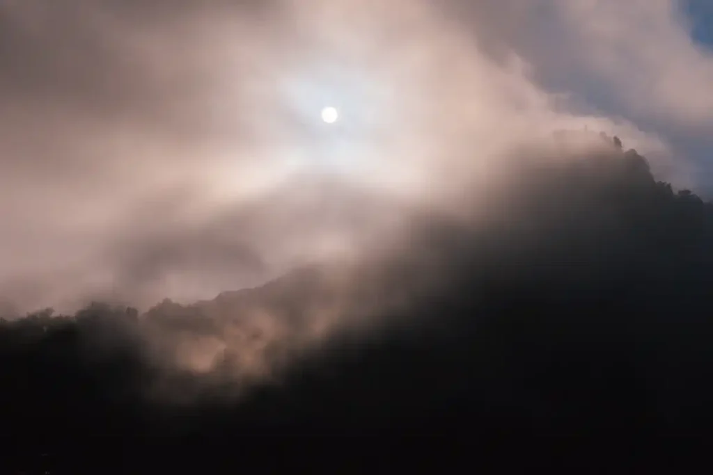 DET SER UT SOM DRACULAS MÅNE MEN DET ÄR SOLEN GENOM MOLNEN PÅ BERGET